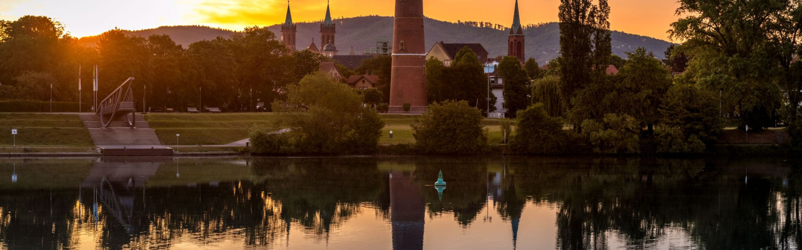 Ansicht auf Ladenburg am Abend. Vom Wasser aus aufgenommen mit Blick auf den Wasserturm und das Bury-Objekt