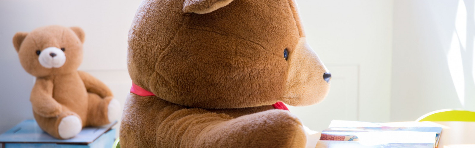 Großer Teddybär sitzt am Tisch